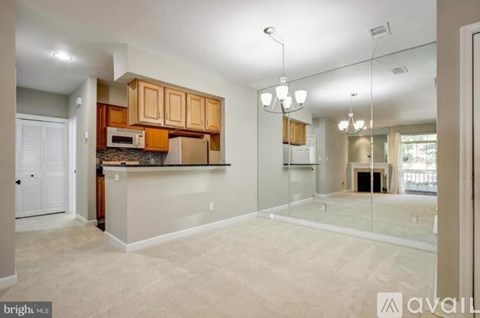 A spacious kitchen with wooden cabinets and a microwave.