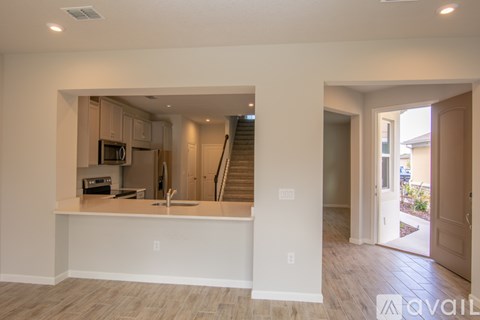 A kitchen area with a counter and stairs in the background.