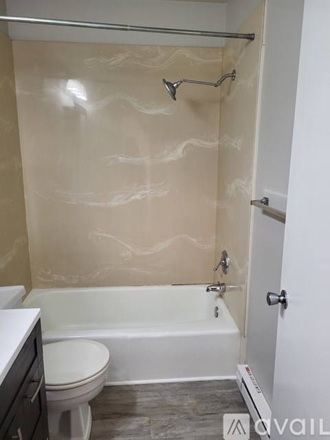 A bathroom with a bathtub, toilet, and a shower with a glass door.