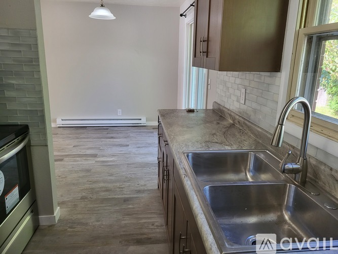 A kitchen with a stainless steel sink and a window.