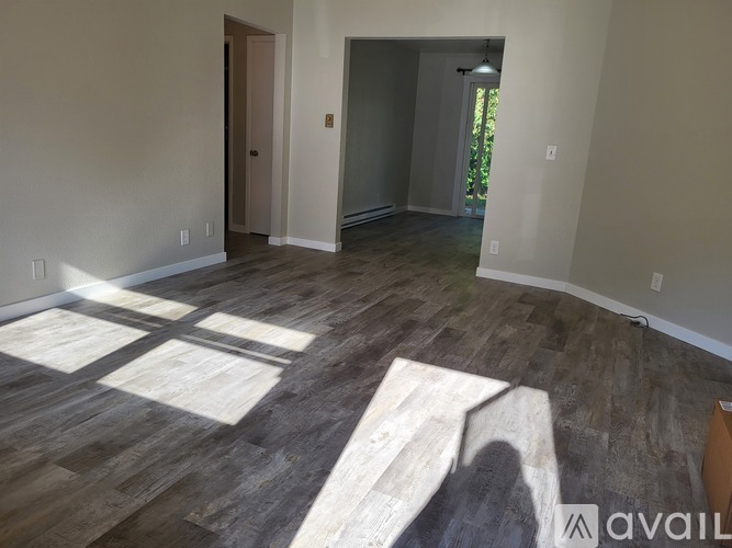 A room with wooden flooring and two doors.