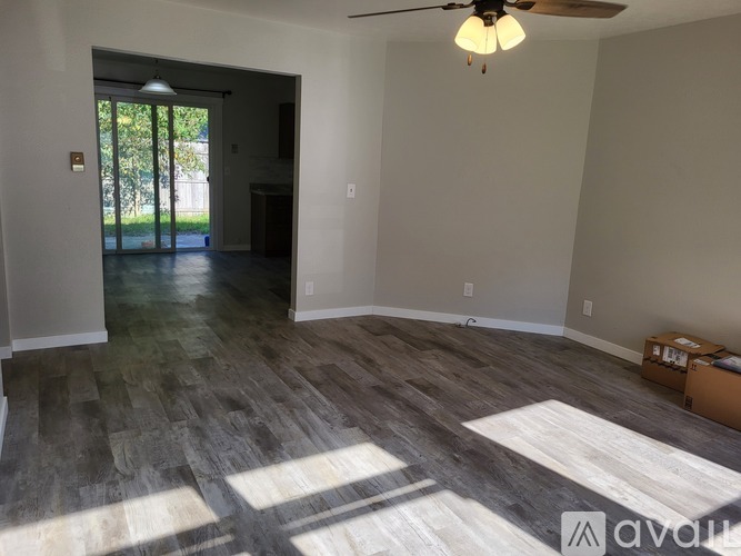 A room with a ceiling fan and a door leading outside.