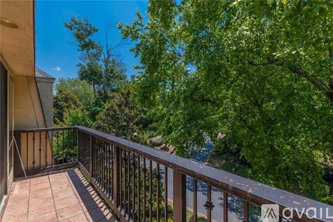 A balcony with a railing and a view of trees and a body of water.