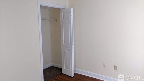 A white door is open to a room with a brown carpet.