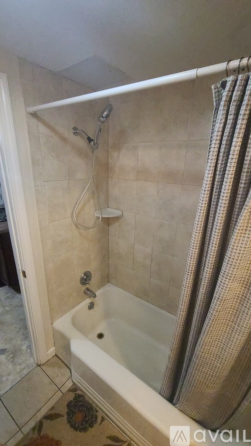 A bathroom with a white tub and a shower curtain.