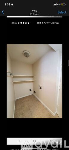 A small, empty room with a ceiling light and a door on the right side.