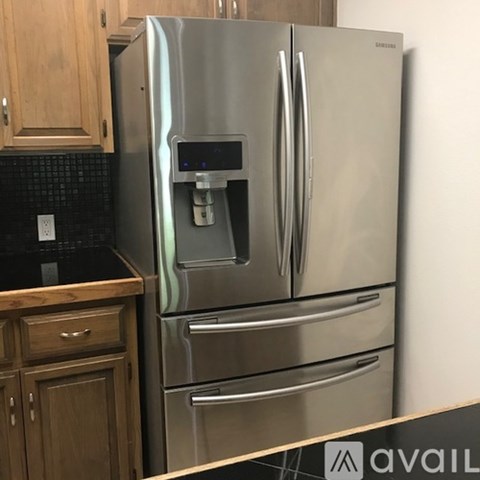 A stainless steel refrigerator with a water dispenser in the middle.