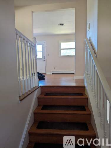 A hallway with a staircase leading to a bedroom.
