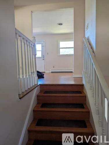 A hallway with a staircase leading to a bedroom.