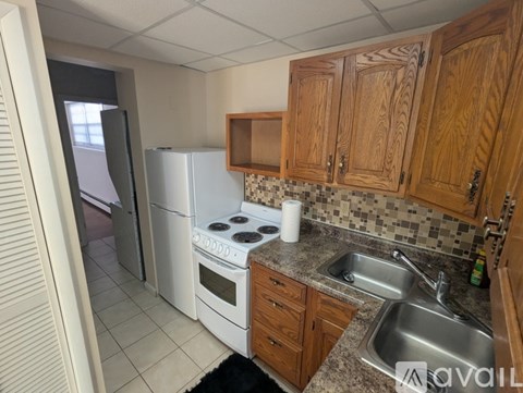 A kitchen with wooden cabinets and a white refrigerator.