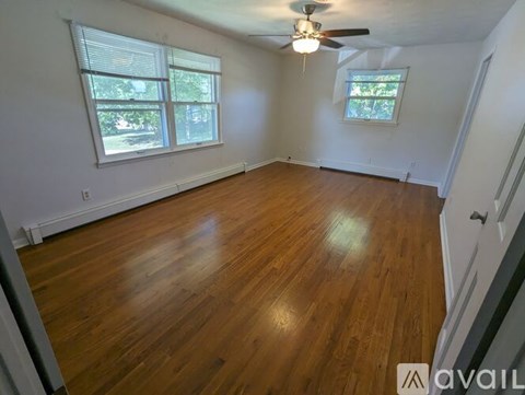 A room with wooden flooring and a ceiling fan.