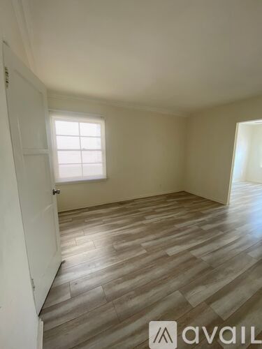 A room with wooden flooring and a window.