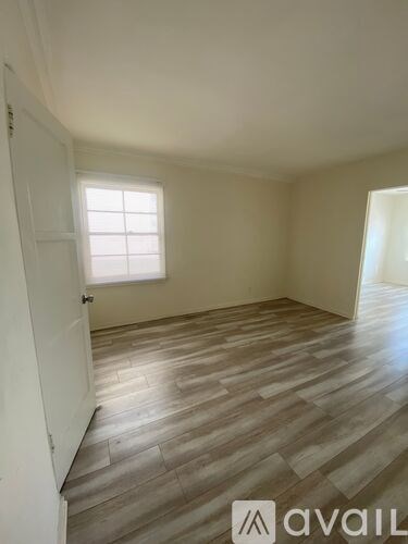 A room with wooden flooring and a window.