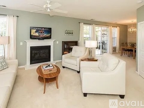 A living room with a fireplace and a television on the wall.