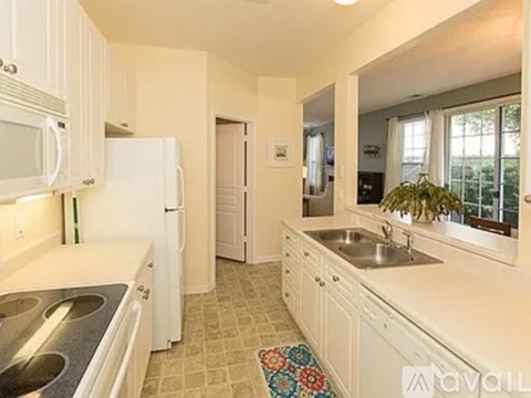 A kitchen with white appliances and cabinets.