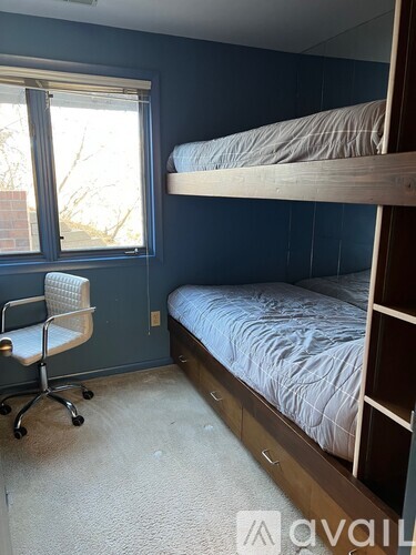 A bedroom with a bunk bed and a desk.