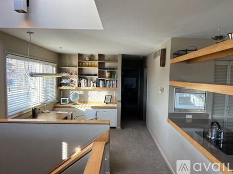 A kitchen with a counter and a window with blinds.
