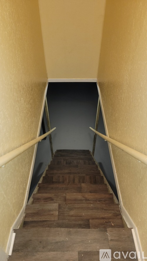 A staircase with wooden steps and white handrails.
