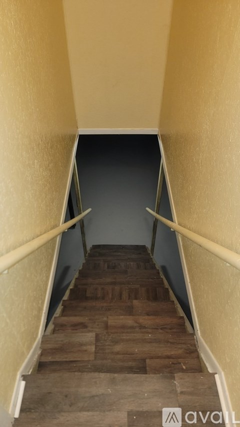 A staircase with wooden steps and white handrails.