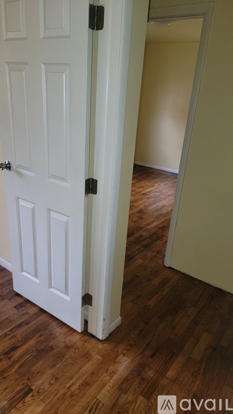 A white door with a black handle is open.