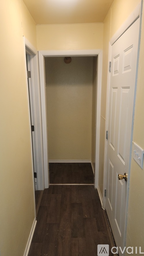 A hallway with a door on the right and a doorway ahead.