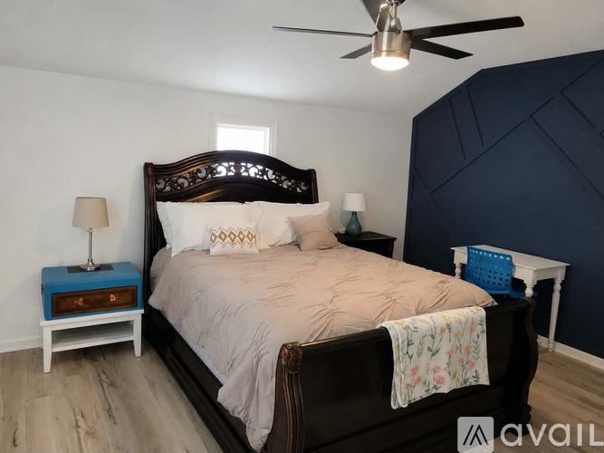 A bedroom with a large bed and a ceiling fan.