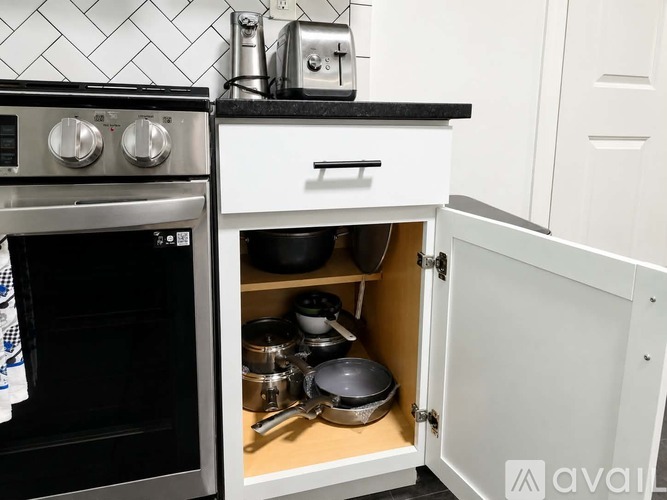 A kitchen with a black oven and white cabinets.