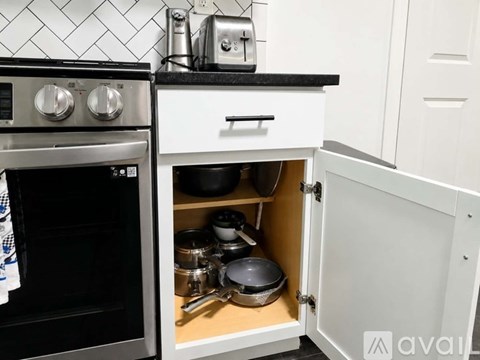 A kitchen with a black oven and white cabinets.
