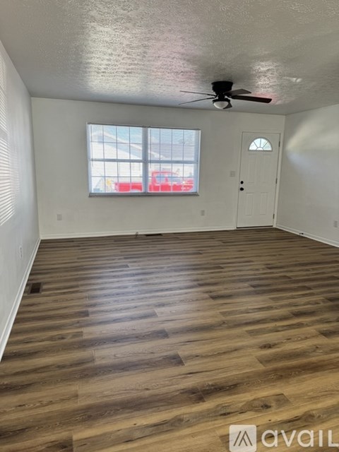 A room with wooden flooring and a ceiling fan.