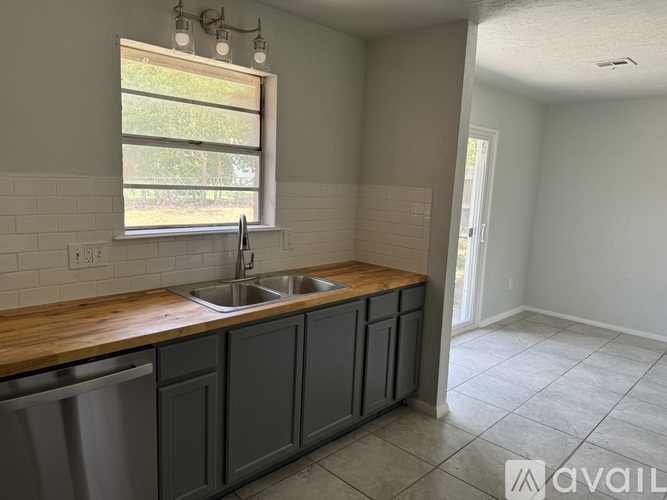 A kitchen with a window above the sink.