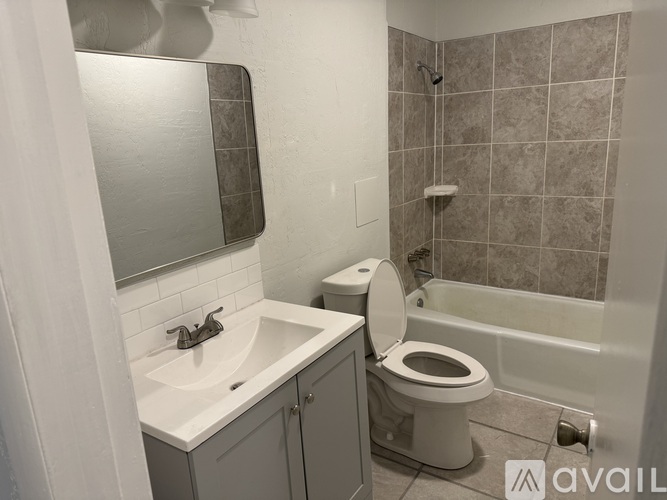A bathroom with a toilet, sink, and bathtub.