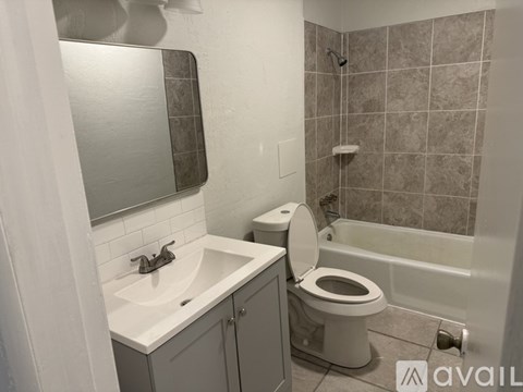 A bathroom with a toilet, sink, and bathtub.
