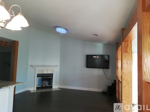 A living room with a fireplace and a television mounted on the wall.