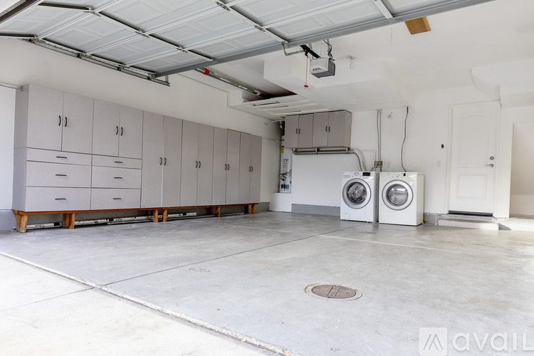 A large, empty room with a washing machine and dryer.