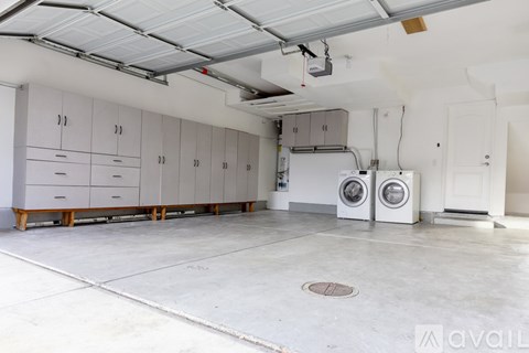 A large, empty room with a washing machine and dryer.
