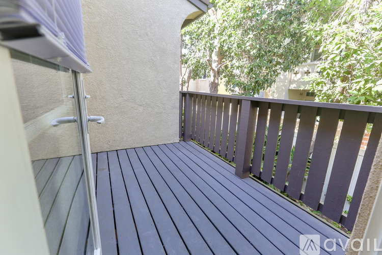 A balcony with a railing and a view of trees.