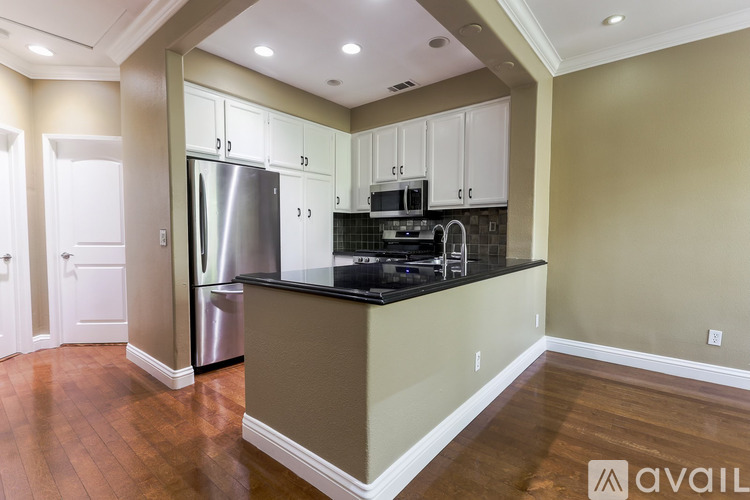 A kitchen with a refrigerator, microwave, and oven.