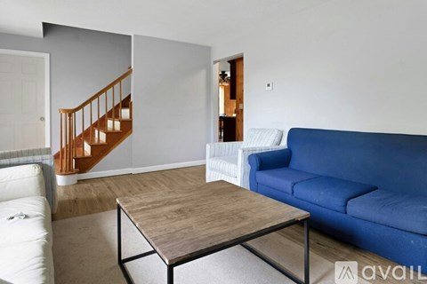 A living room with a blue couch and a wooden coffee table.