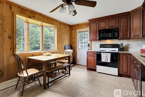 A kitchen with wooden cabinets and a black microwave above the stove.