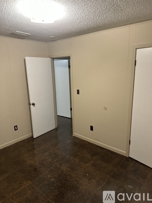 A room with a brown floor and white walls.