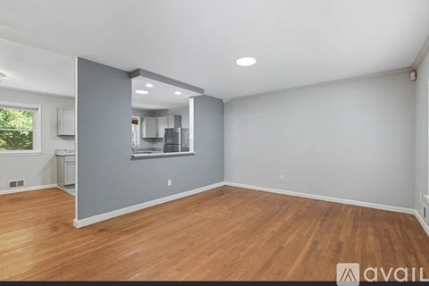 A room with wooden floors and a wall with a window.