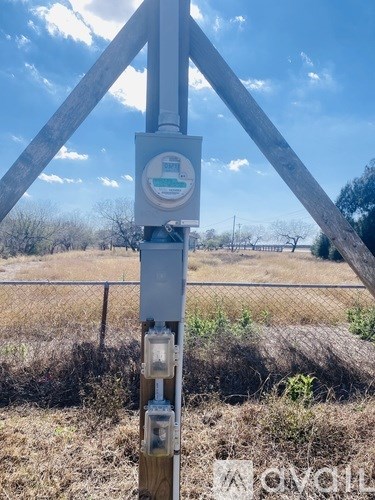 A utility pole with a meter and a small box attached to it.