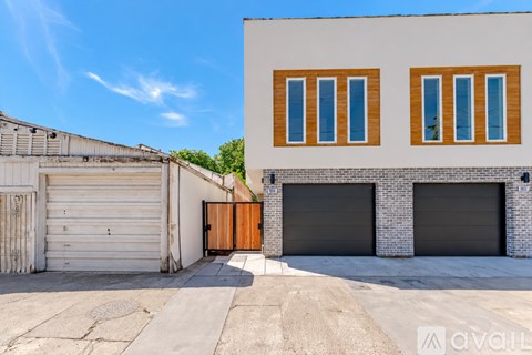 A two-story building with a garage door and windows.