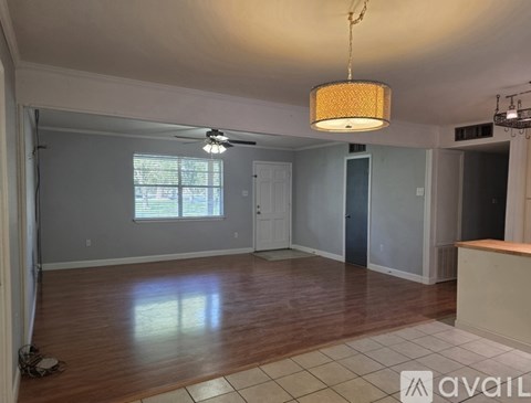 A room with wooden floors and a hanging light fixture.