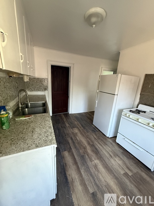 A kitchen with white cabinets and a granite countertop.