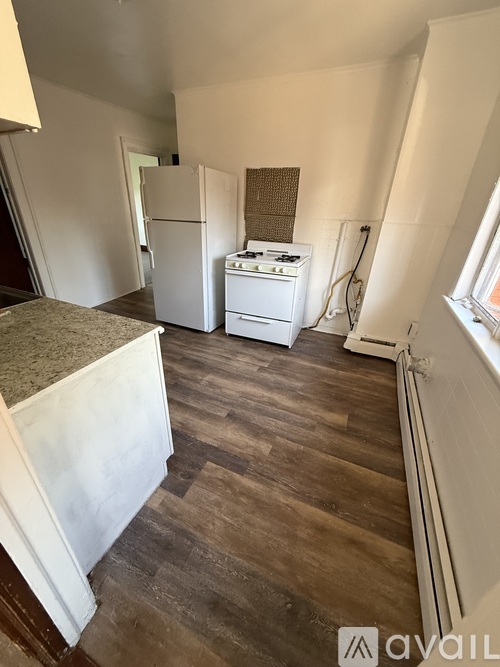 A kitchen with a white fridge, stove and a window.