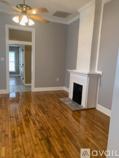 A room with a fireplace and wood flooring.