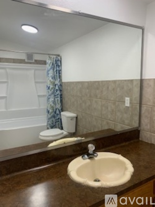 A bathroom with a brown counter top and a white sink.