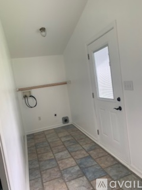 A bathroom with a tiled floor and a white door.