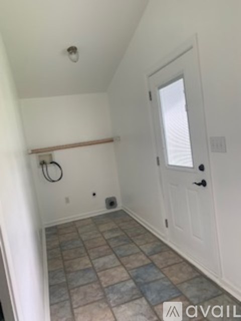 A bathroom with a tiled floor and a white door.